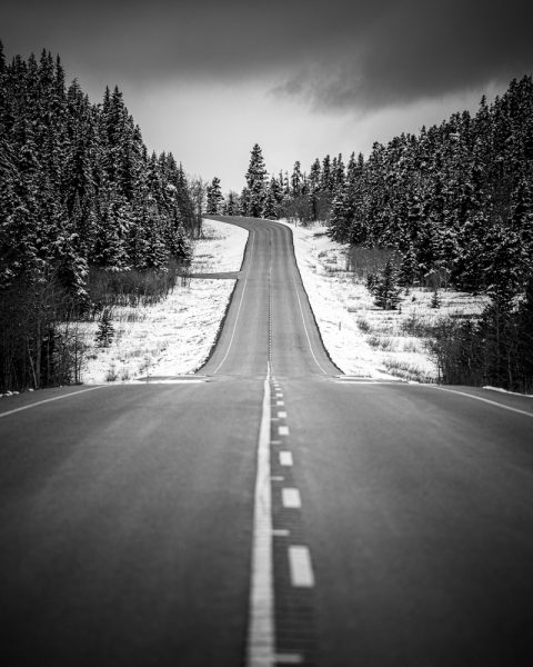 Black and white photo of a road through the snow in Canada