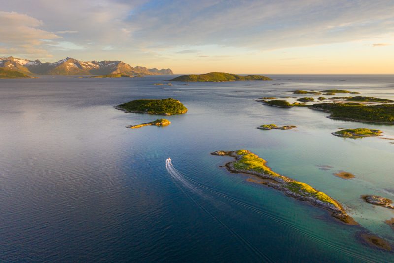 A boat driving through the sea at midnight in norway